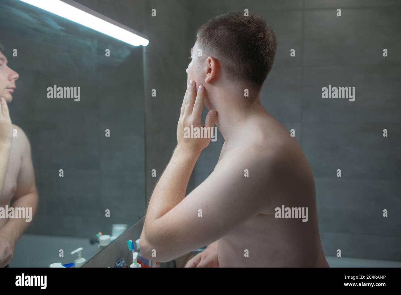 Guy looks in the mirror before shaving Stock Photo