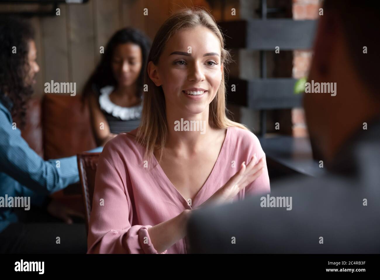 Woman participating in speed dating chatting with guy in cafe Stock Photo