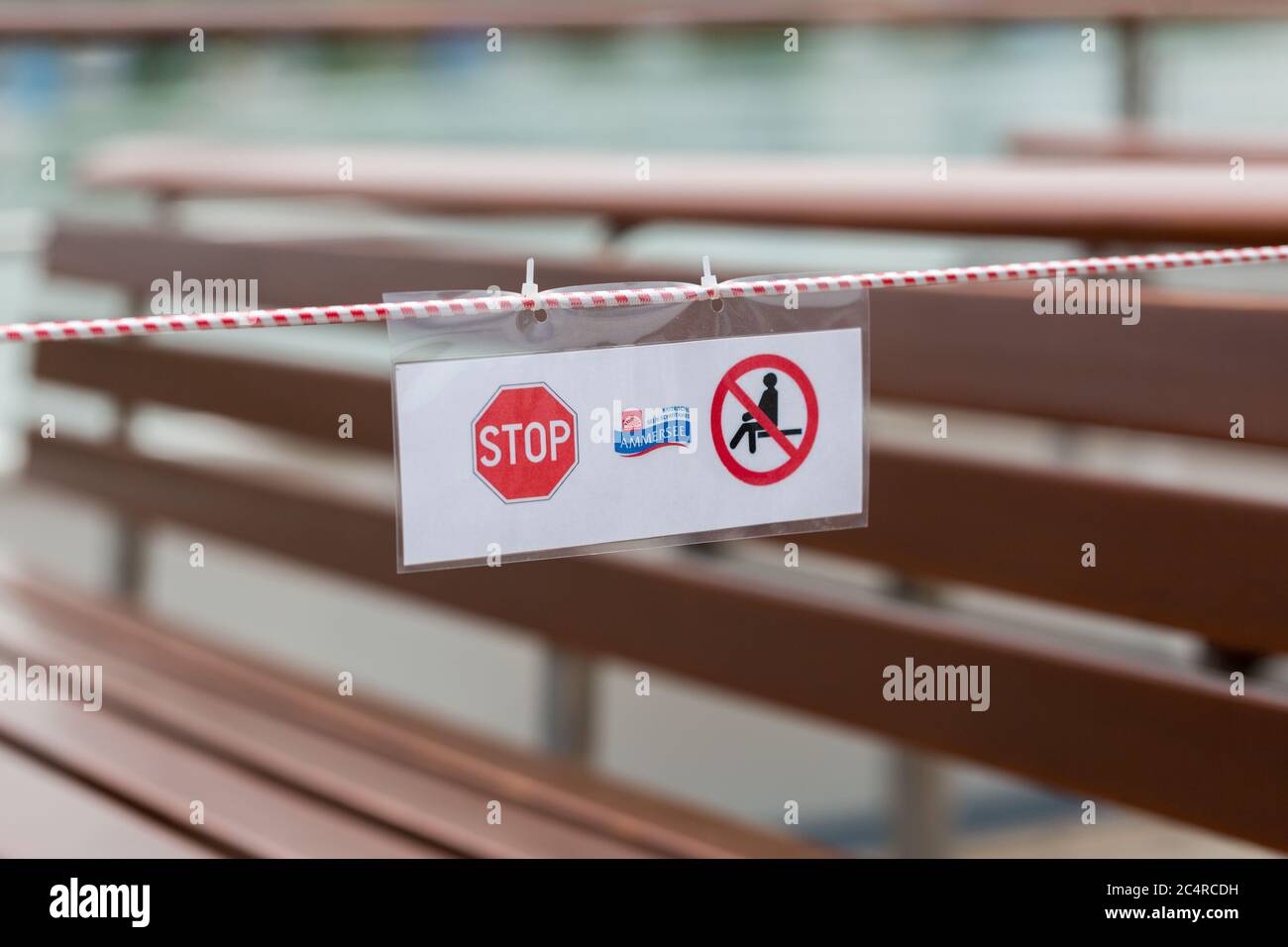 'Do not sit' sign at an excursion boat at Ammersee (Lake Ammer). Every second bench has been closed off to prevent the spread of the coronavirus. Stock Photo