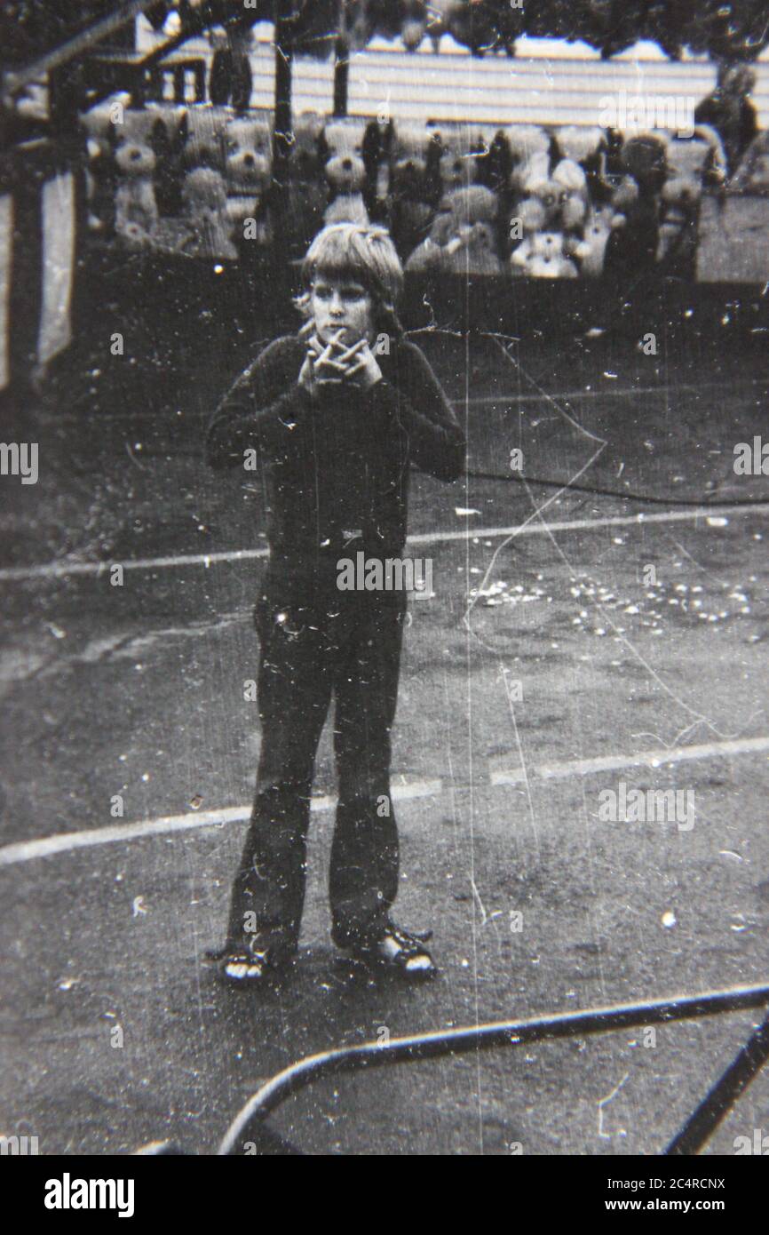 Fine 70s vintage black and white photography of a regular boy standing around on the street. Stock Photo