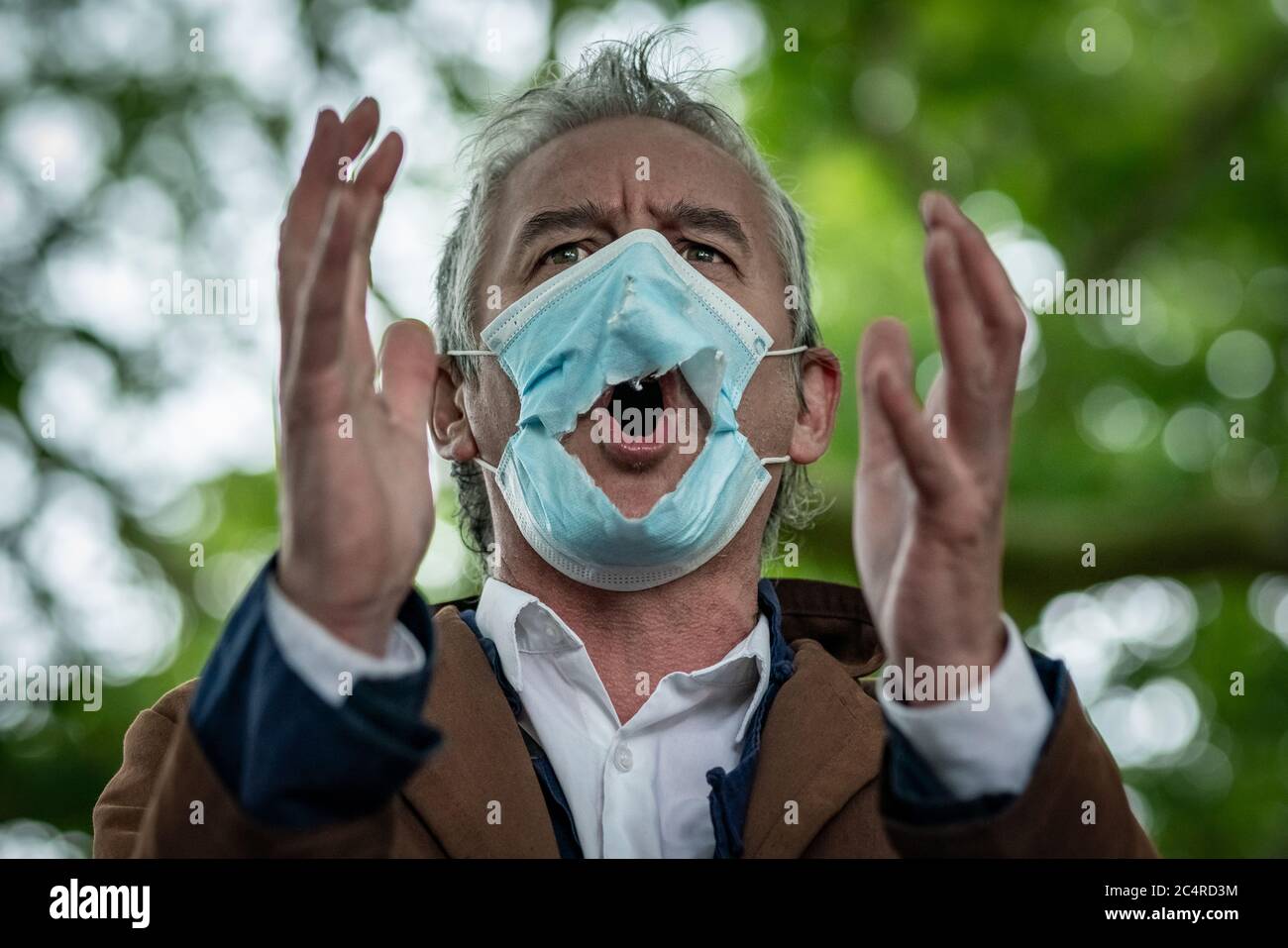 London, UK. 28th June, 2020. Heiko Khoo, a veteran speaker at Speakers’ Corner, debates through a gradually deteriorating face mask whilst observing social distancing. Preaching, debates and sermons at Speakers’ Corner, the public speaking north-east corner of Hyde Park. Credit: Guy Corbishley/Alamy Live News Stock Photo