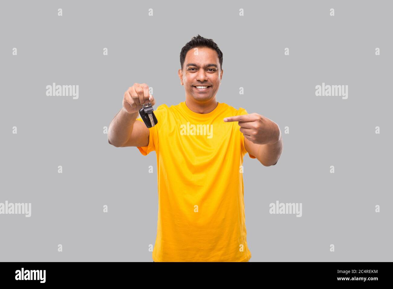 Indian Man Smilling Pointing at Car Keys Isolated. Driver Stock Photo