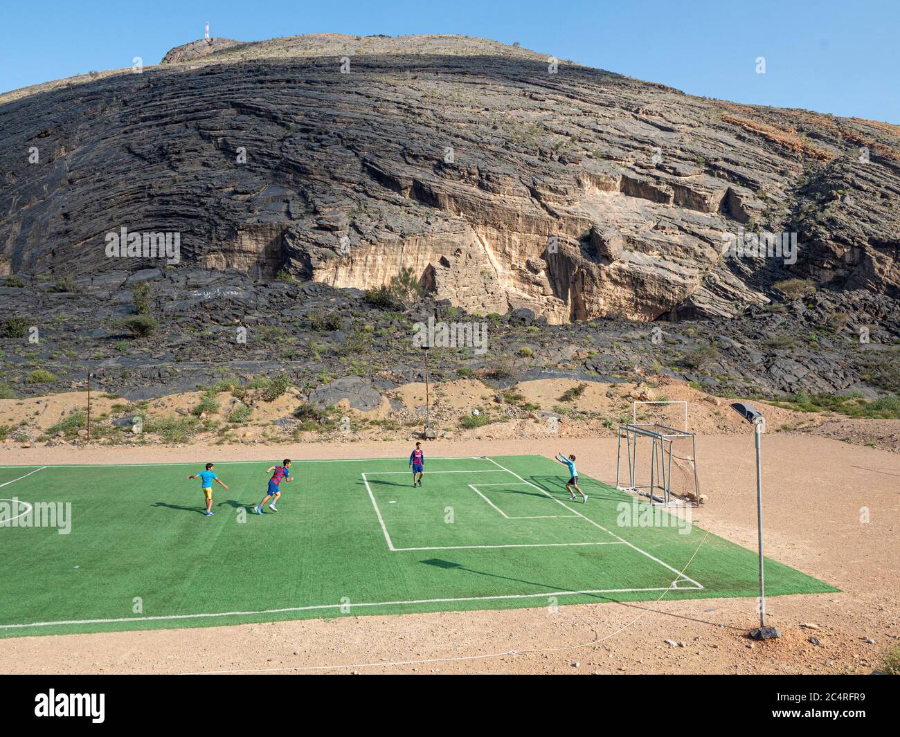 Kids playing soccer near Bilad Sayt, a mountain village located in the Al Hajar Mountains, Sultanate of Oman. Stock Photo