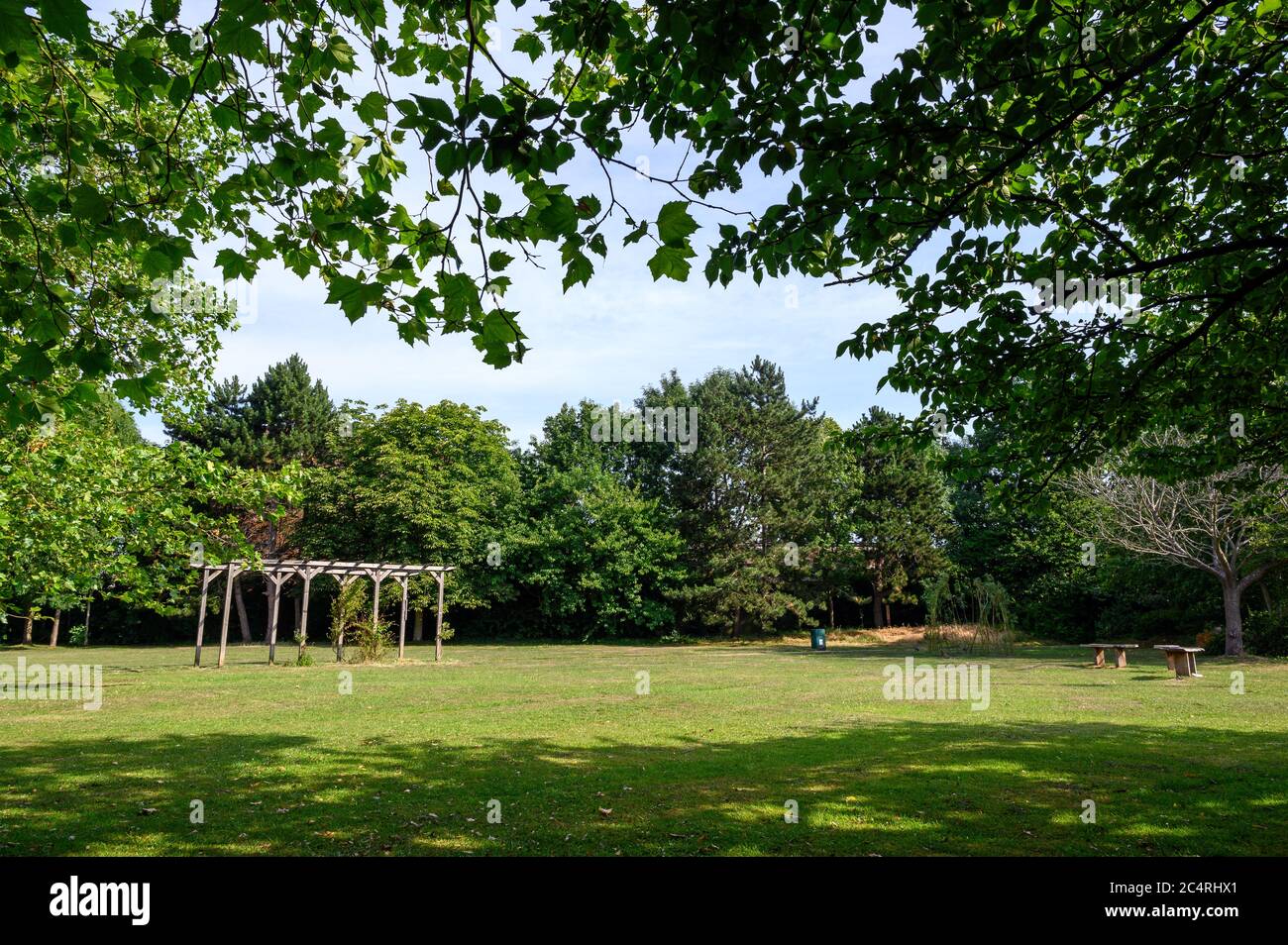 College Green in Bromley (London), Kent. This open space near the center of Bromley has grass, flowers and trees. Photo shows seats and a pergola. Stock Photo