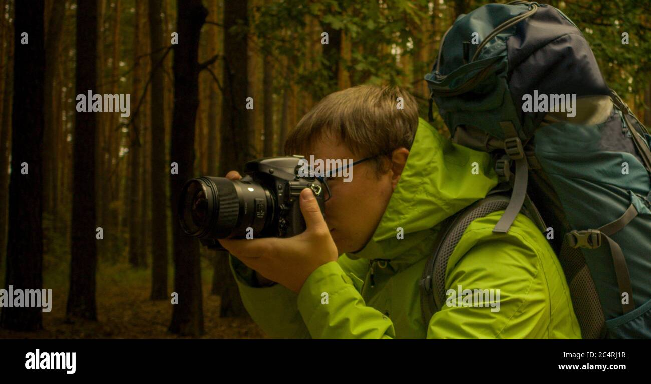 the photographer holds a professional dslr camera near the face while shooting Close-up Stock Photo