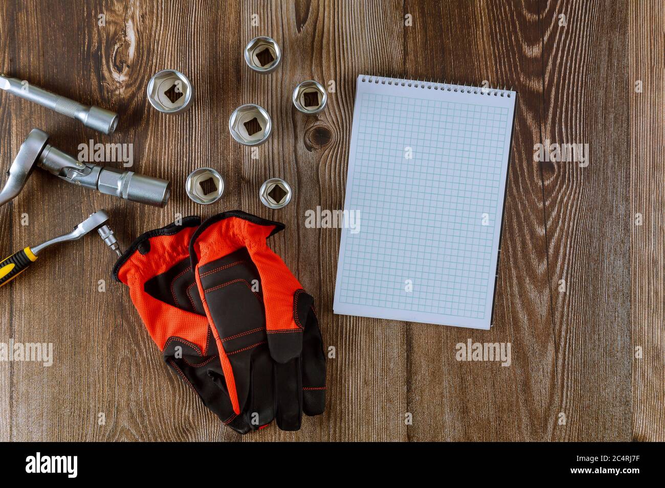 Setting spiral notepad of tools for auto mechanic, working gloves in spanner wrench automobile on wood background Stock Photo