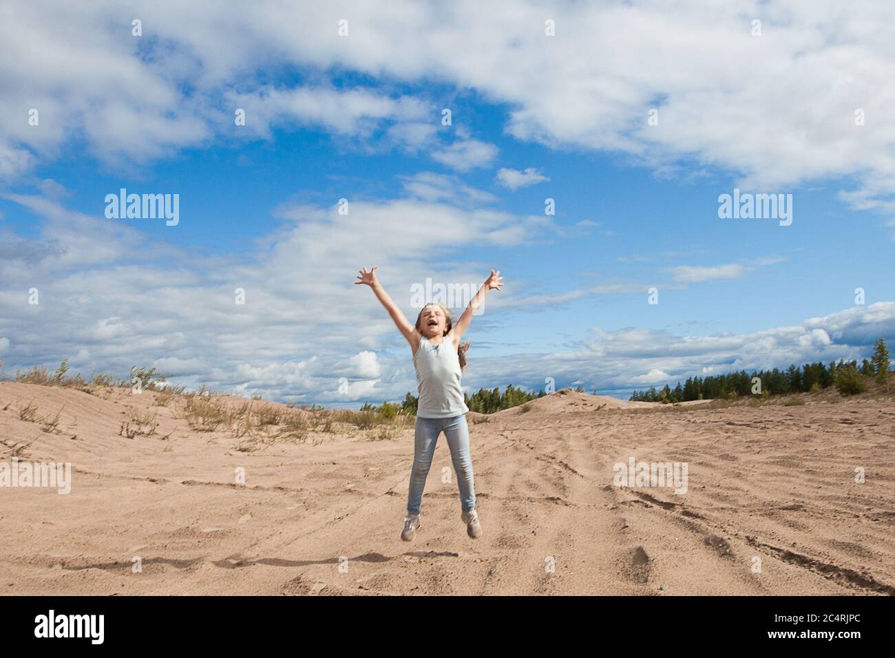 Happy child girl jumping against sky clouds outdoors Stock Photo - Alamy