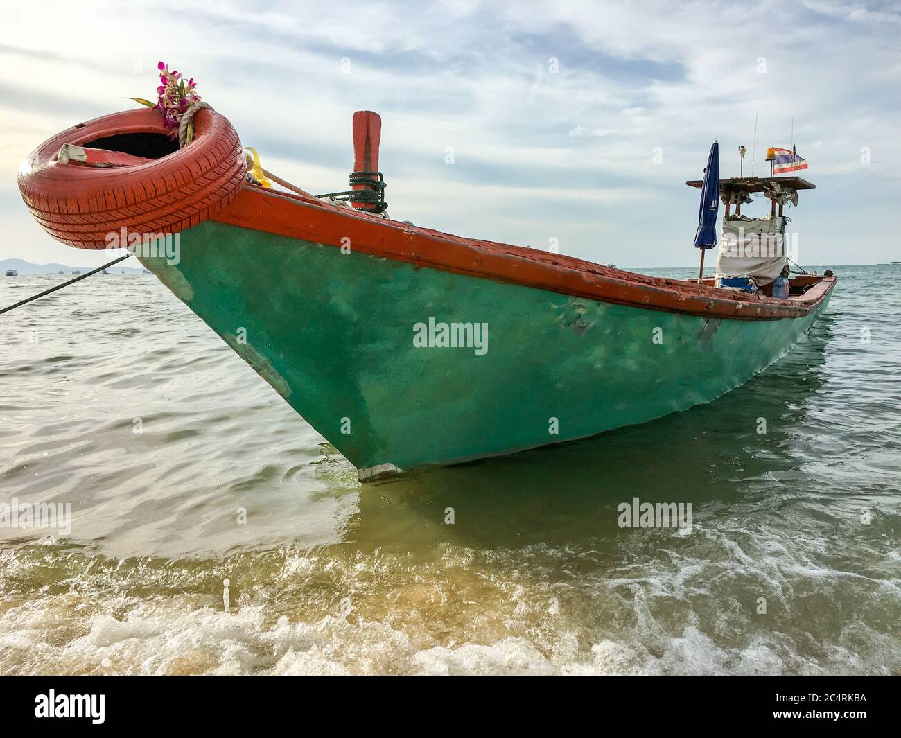 Anchored longtail boat on the coast of the Andaman Sea in Thailand. Long tail boat on beach. Stock Photo