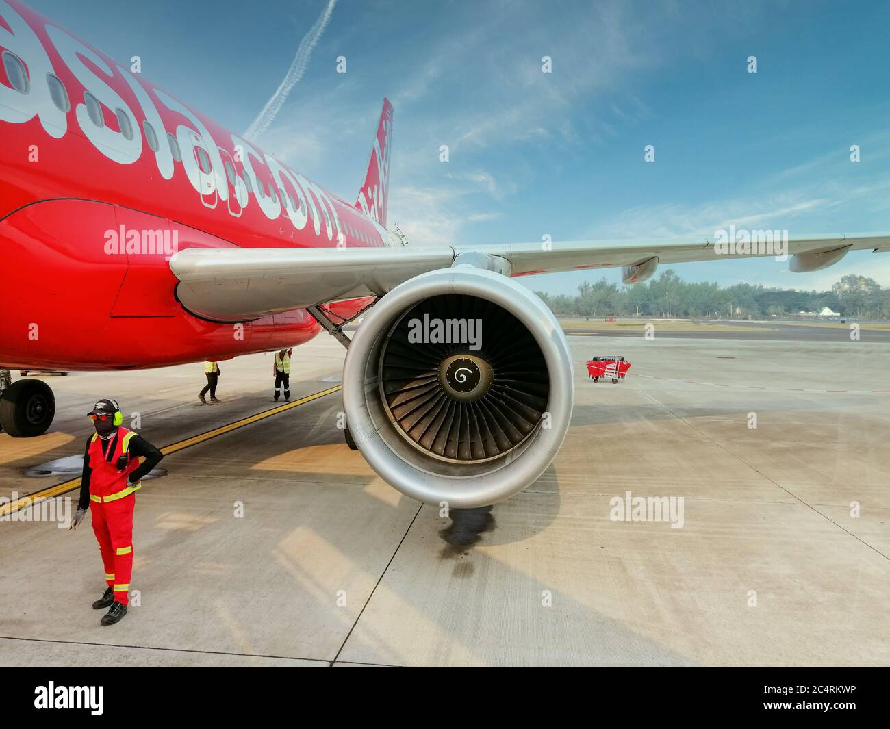 Nan/Thailand- February 2020: An aircraft of Air Asia Airlines is parking at Nan Airport during the boarding time. Passengers are walking to the aircra Stock Photo