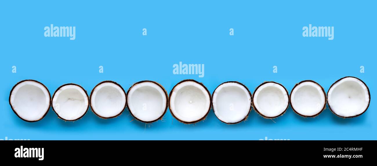Half Coconuts on blue background. Copy space Stock Photo