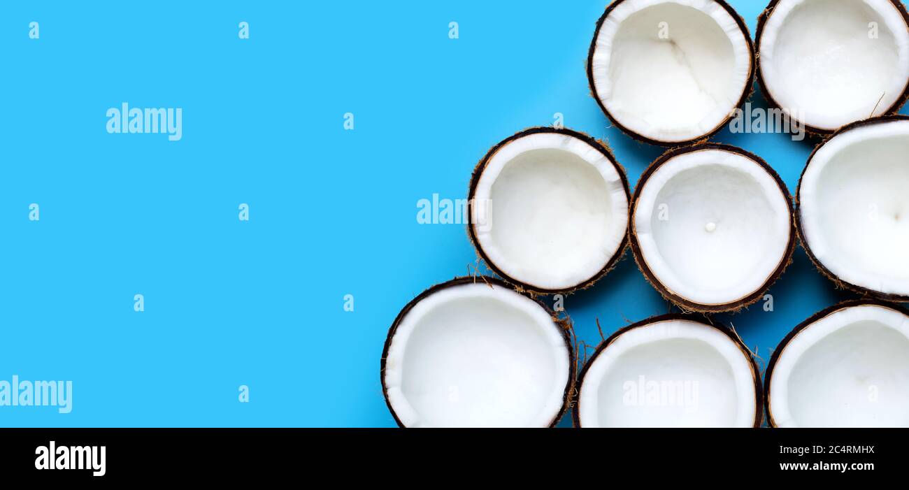 Half coconuts on blue background. Top view Stock Photo