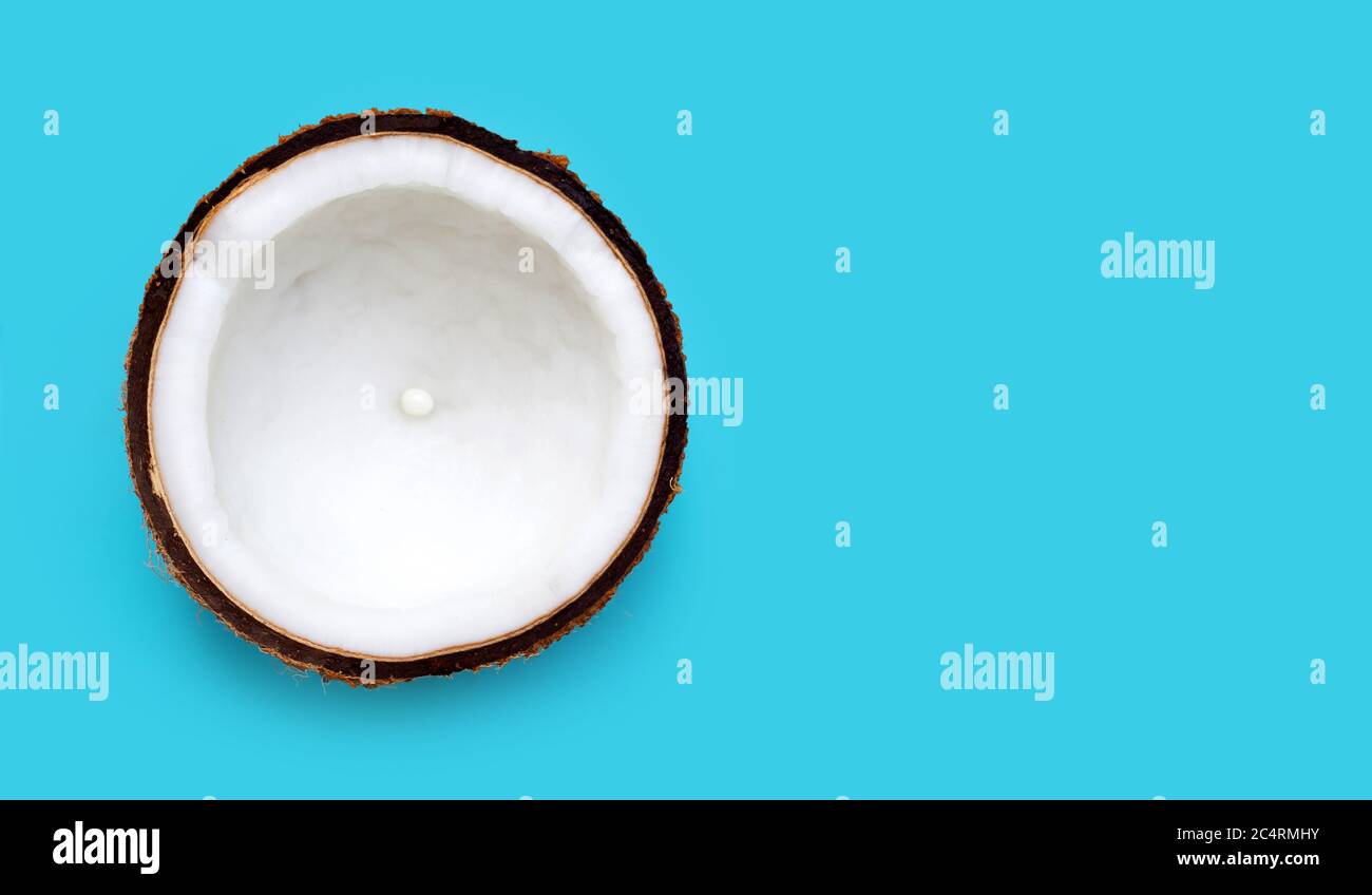 Half Coconut on blue background. Copy space Stock Photo - Alamy