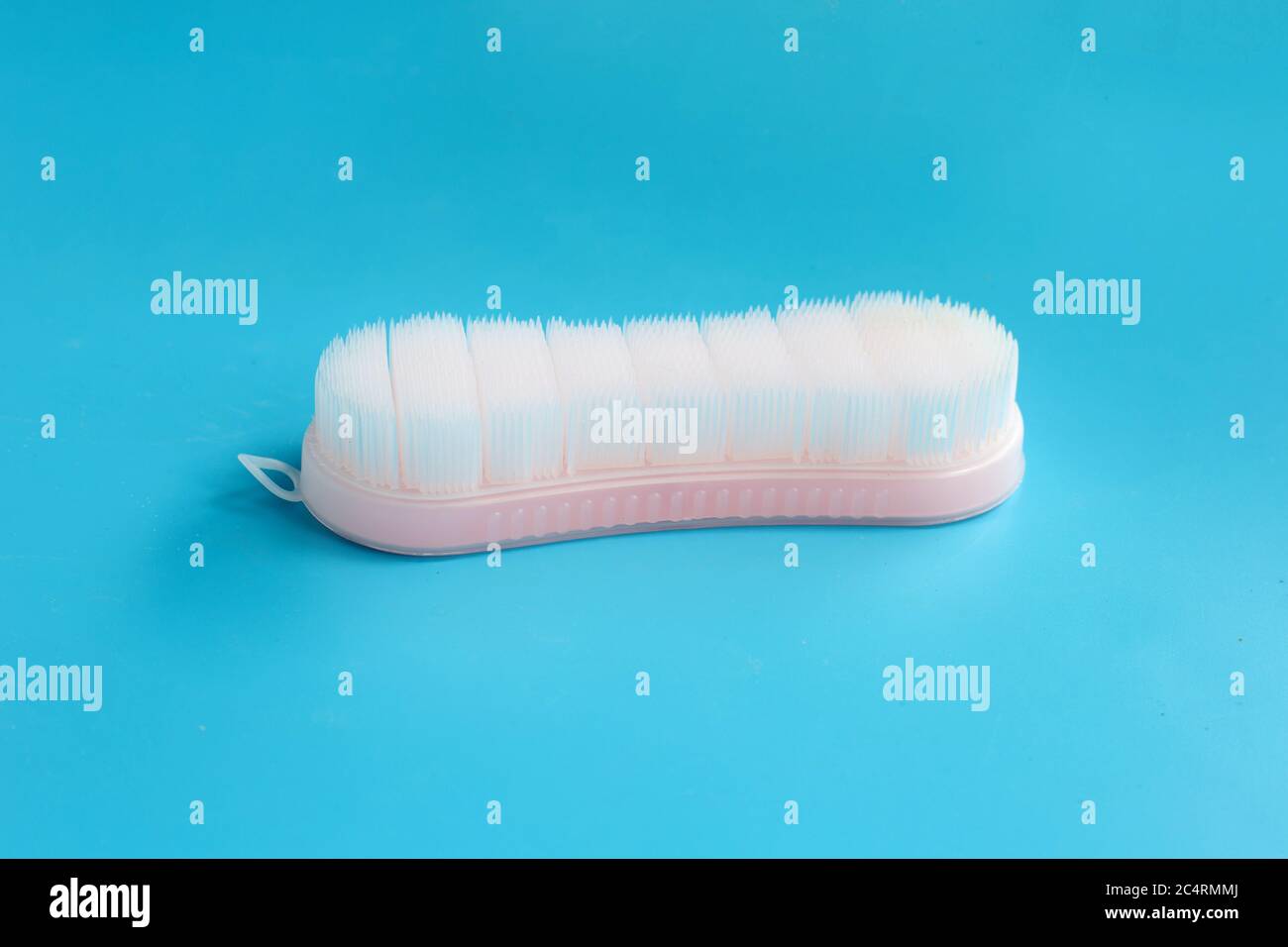 Brush for cleaning clothes on blue background. Stock Photo