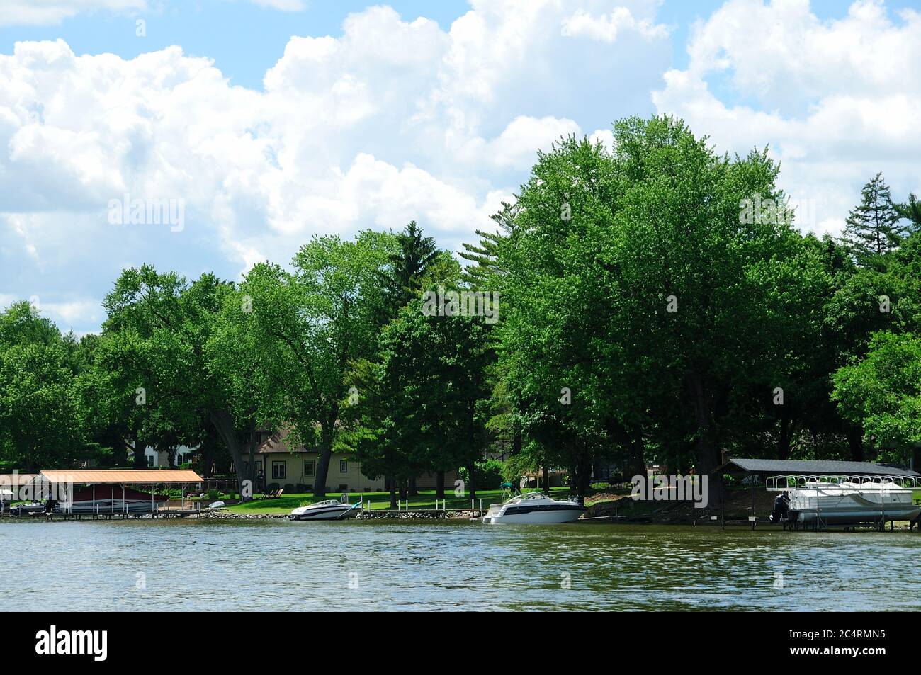 Boats and piers lining the shore of the Fox River in Northern Illinois, USA. Stock Photo