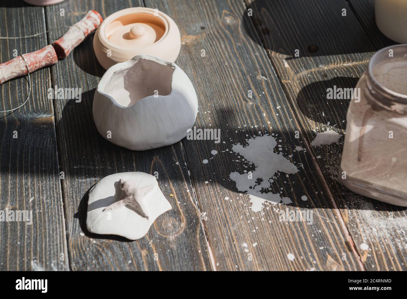 Art of pottery. Still life of pottery making tools, brushes and different ceramic vases and bowls in clay studio Stock Photo