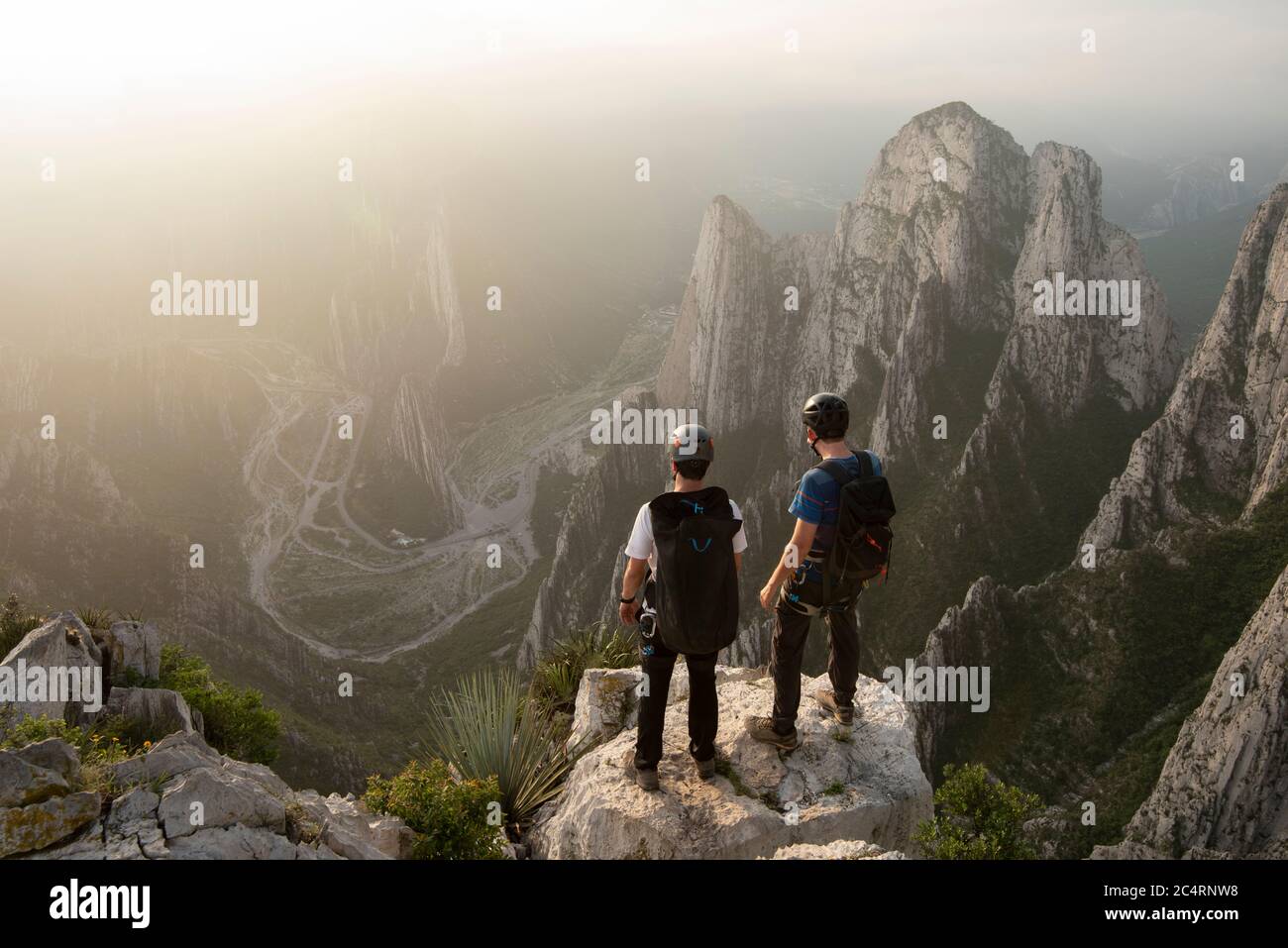 Two friends standing on a rock at a cliff in Nido de Aguiluchos Stock Photo