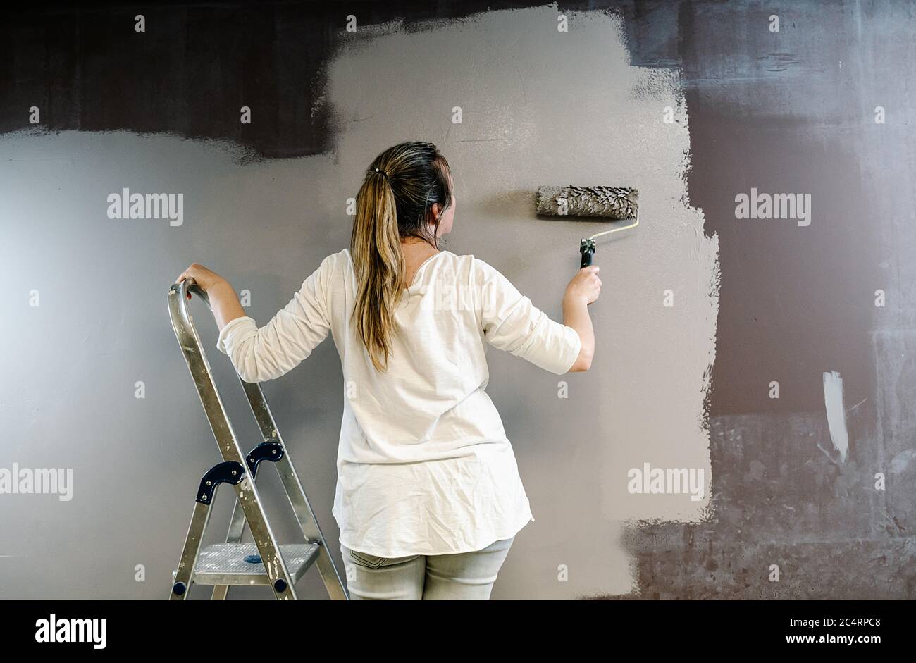 Woman on ladder painting wall hi-res stock photography and images - Alamy