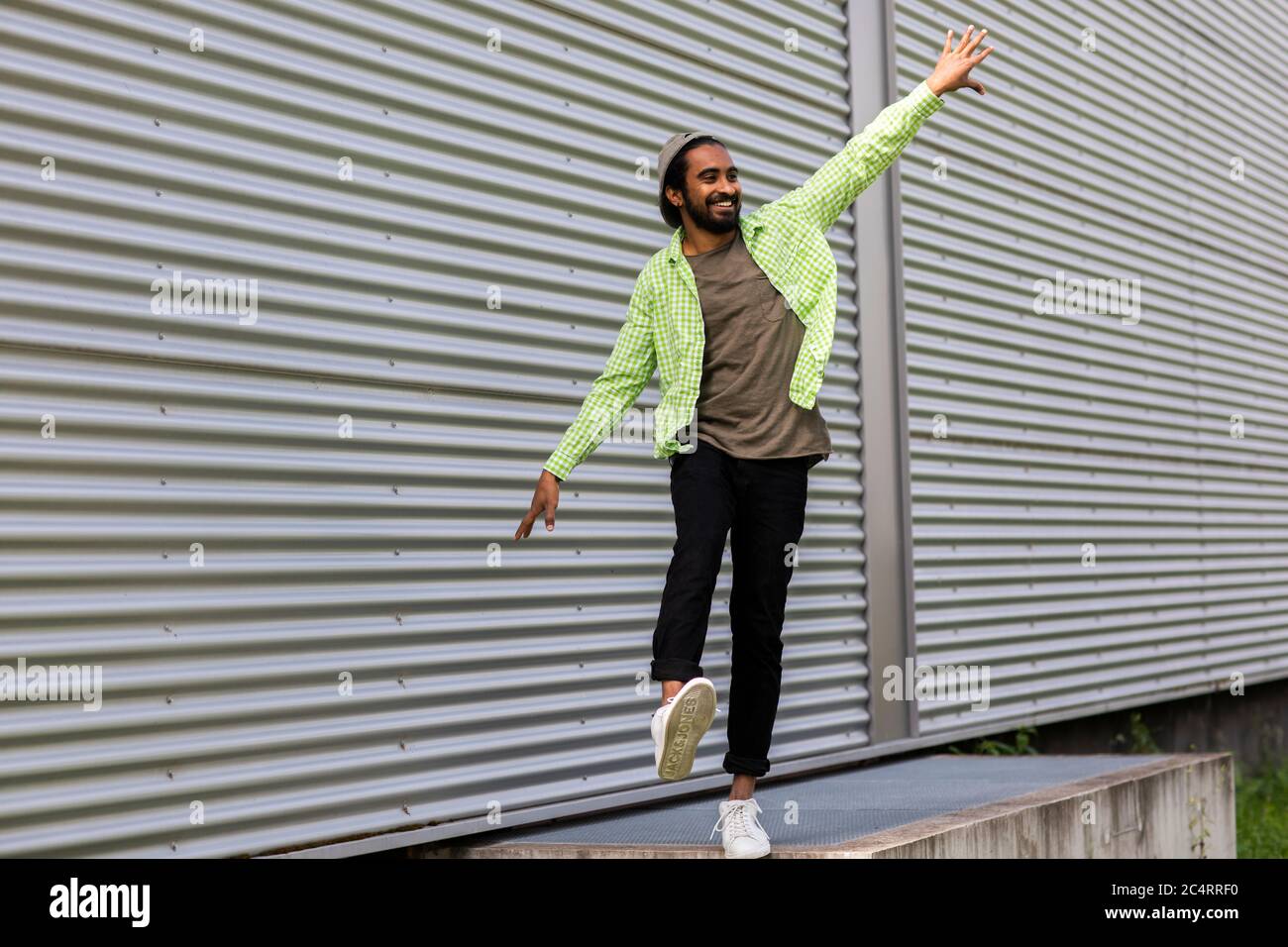 young man in front corrugated iron wall Stock Photo