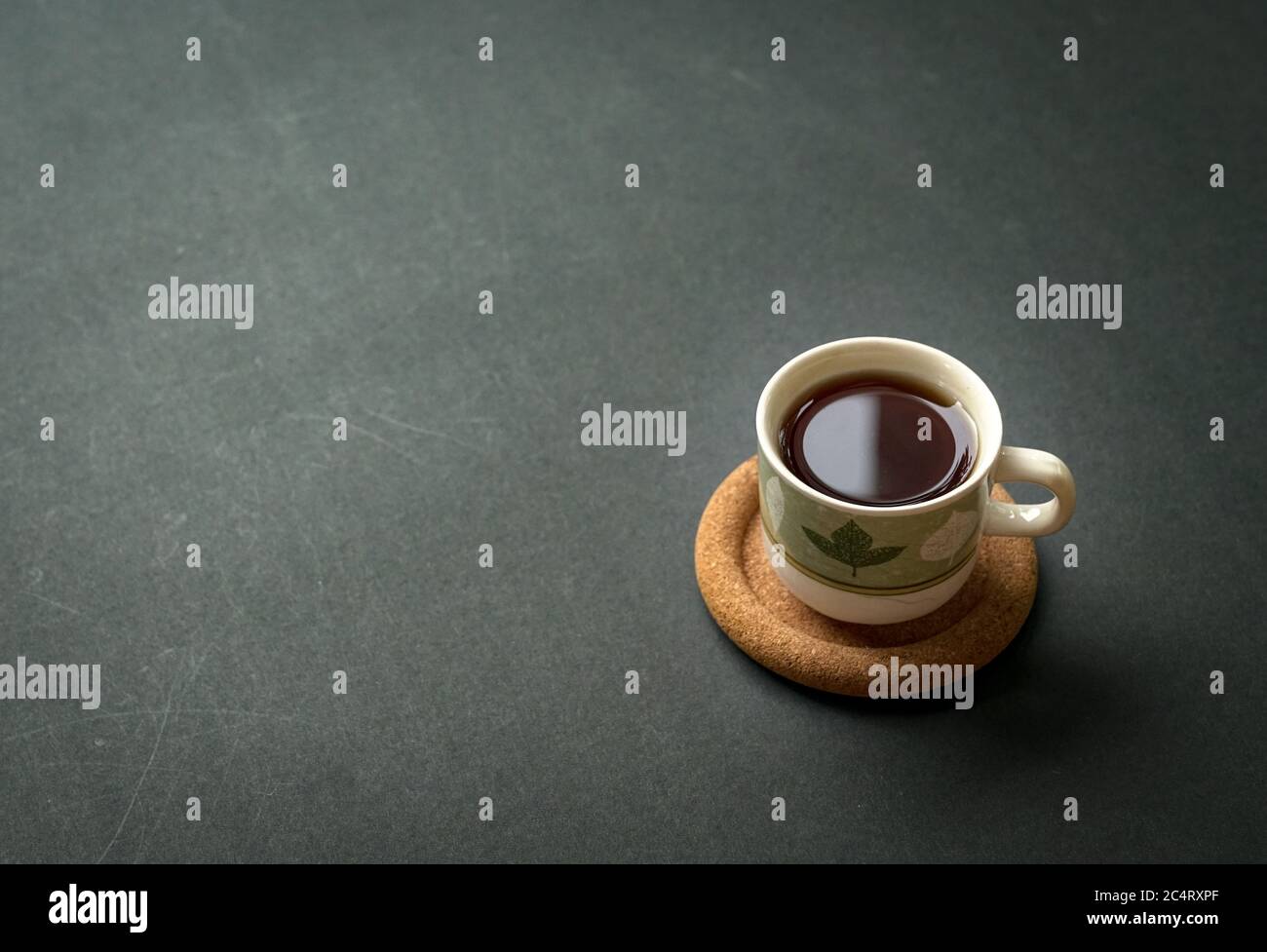 Coffee cup on rustic black tabletop. Top view with copy space for text