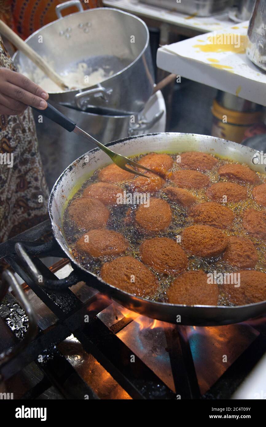 Acarajé, a dish sold by street vendors in Salvador de Bahia, Brazil made of peeled and mashed beans fried in dendê oil and often stuffed with shrimp. Stock Photo