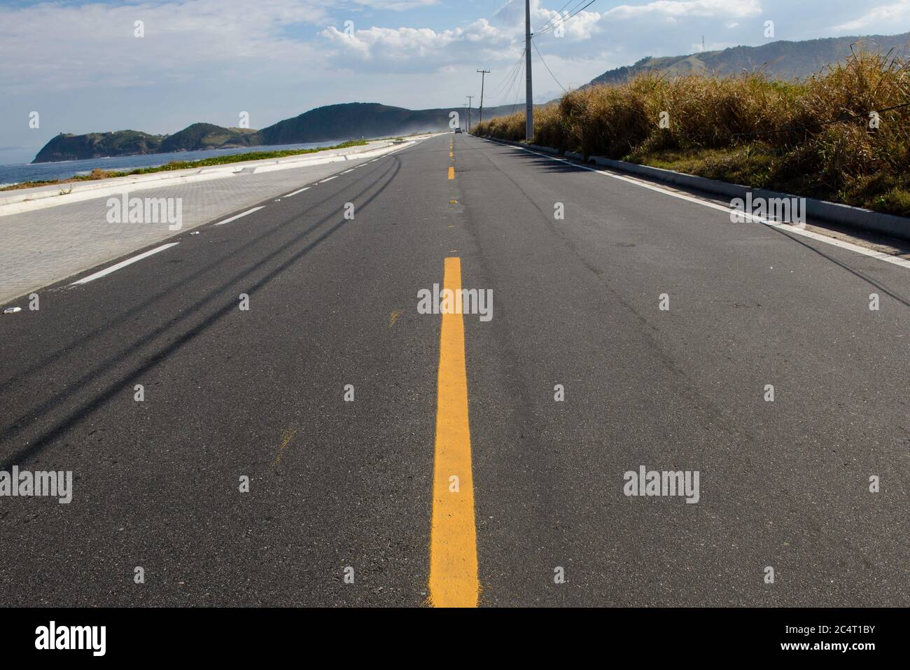 simple road with yellow strip dividing the lanes Stock Photo