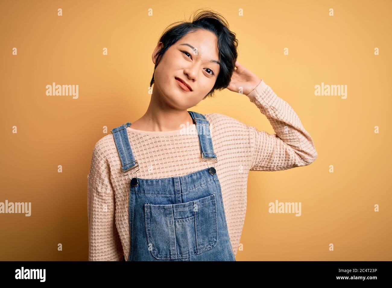 Young beautiful asian girl wearing casual denim overalls over isolated ...