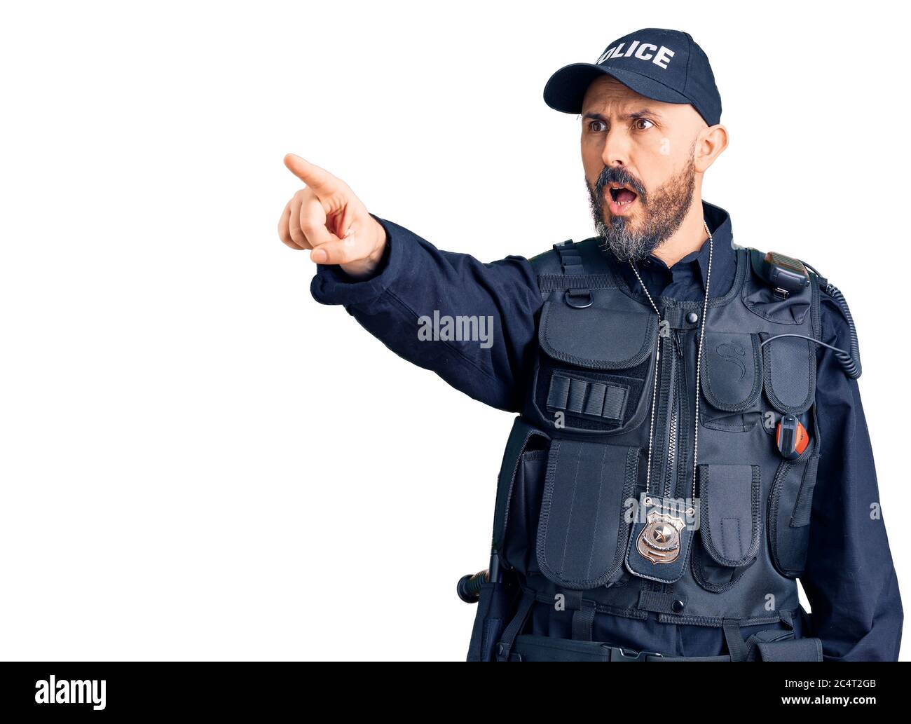 Young handsome man wearing police uniform pointing with finger surprised ahead, open mouth amazed expression, something on the front Stock Photo