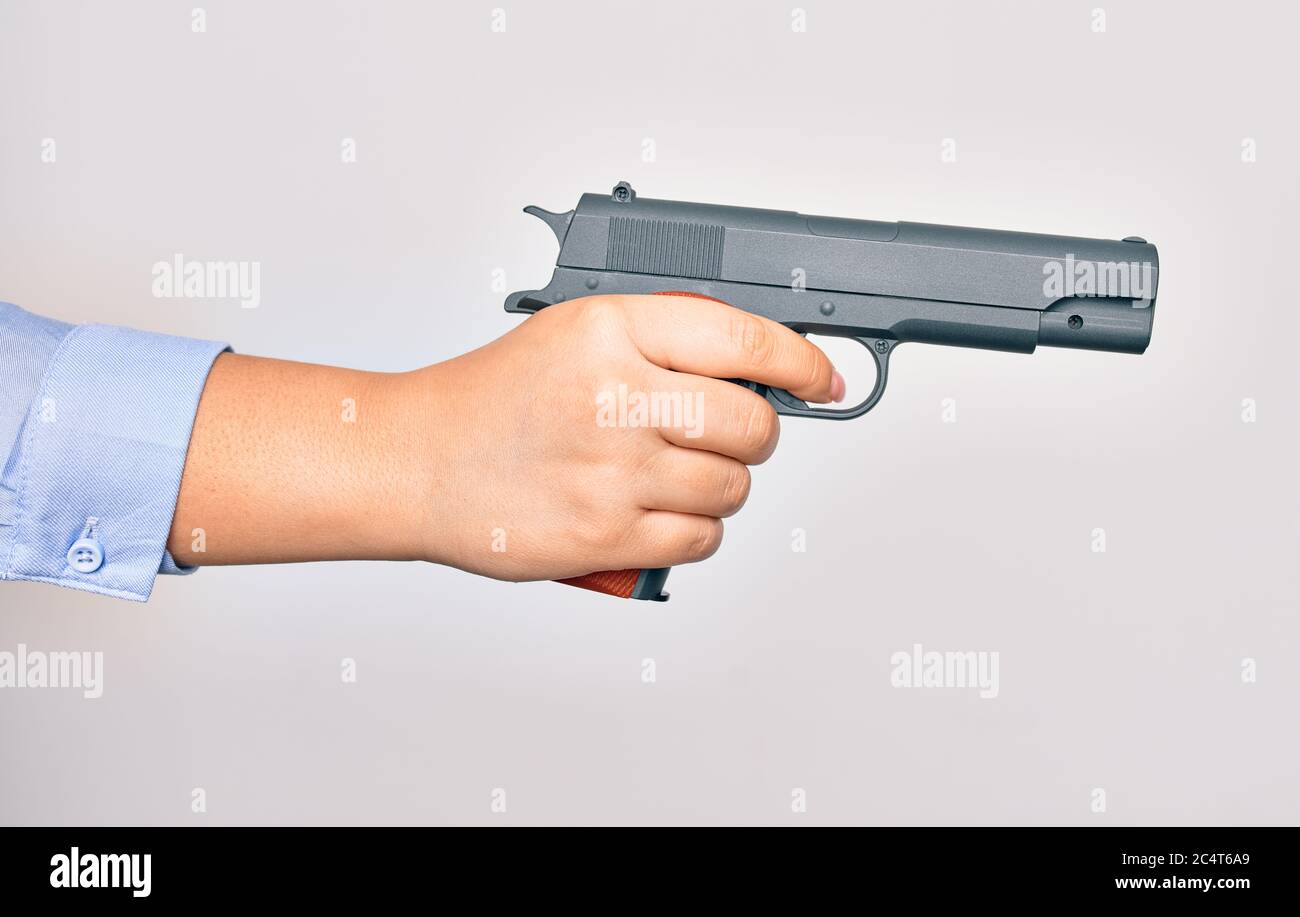 Hand of caucasian young woman holding gun over isolated white