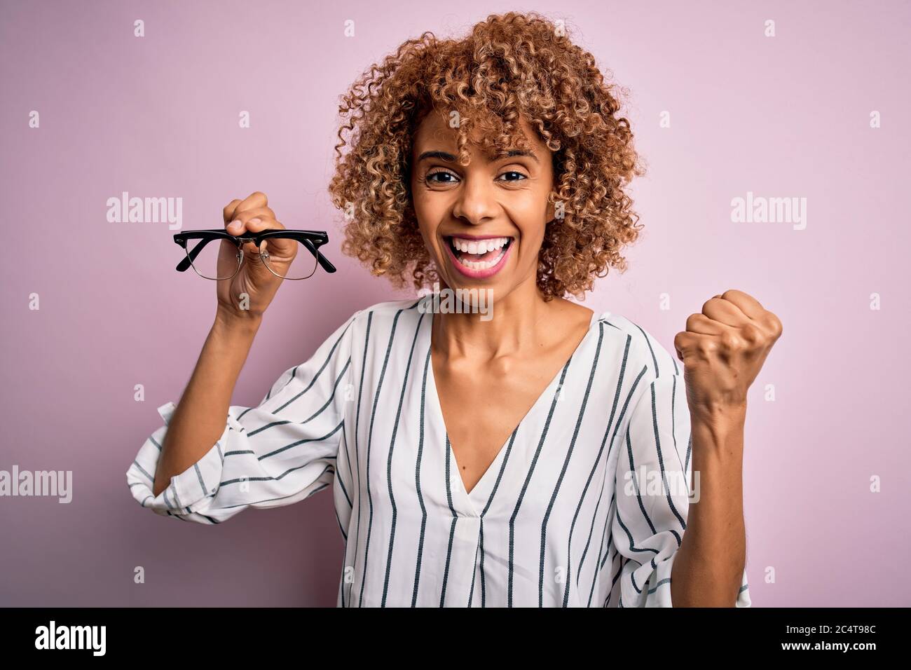 African american optical woman with curly hair holding glasses over ...