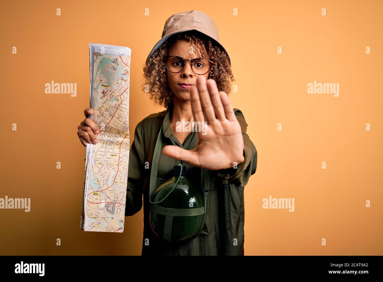 African american tourist woman wearing explorer hat and water canteen ...