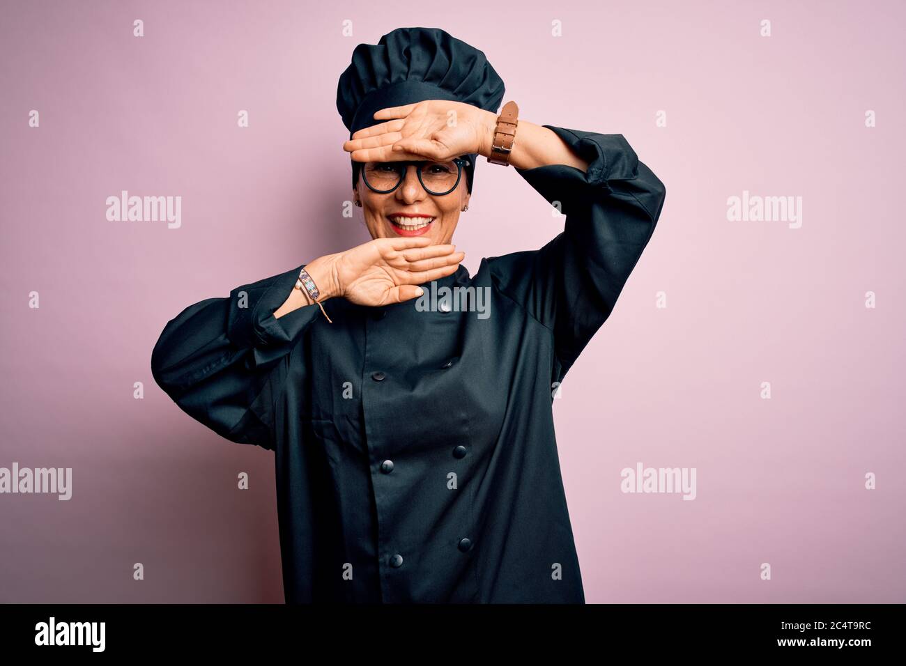 Middle age brunette chef woman wearing cooker uniform and hat over ...