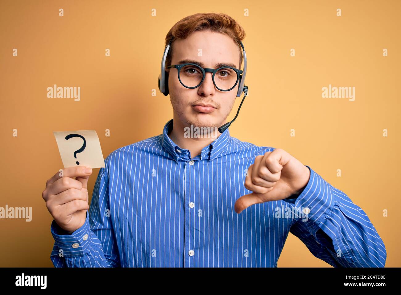 Redhead call center agent man working using headset holding reminder ...