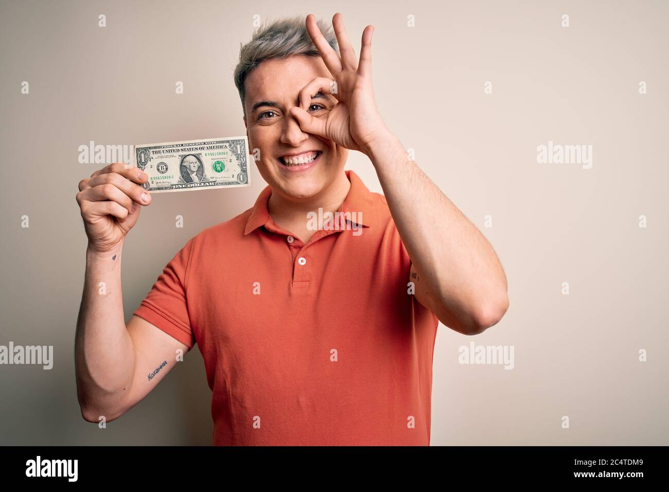 Young modern handsome man holding 1 USA banknote dollar over isolated ...