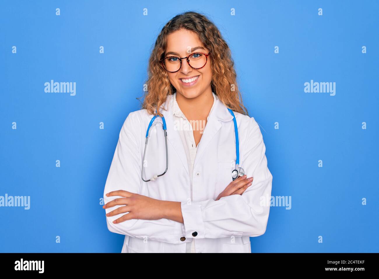 Young beautiful blonde doctor woman with blue eyes wearing coat and ...