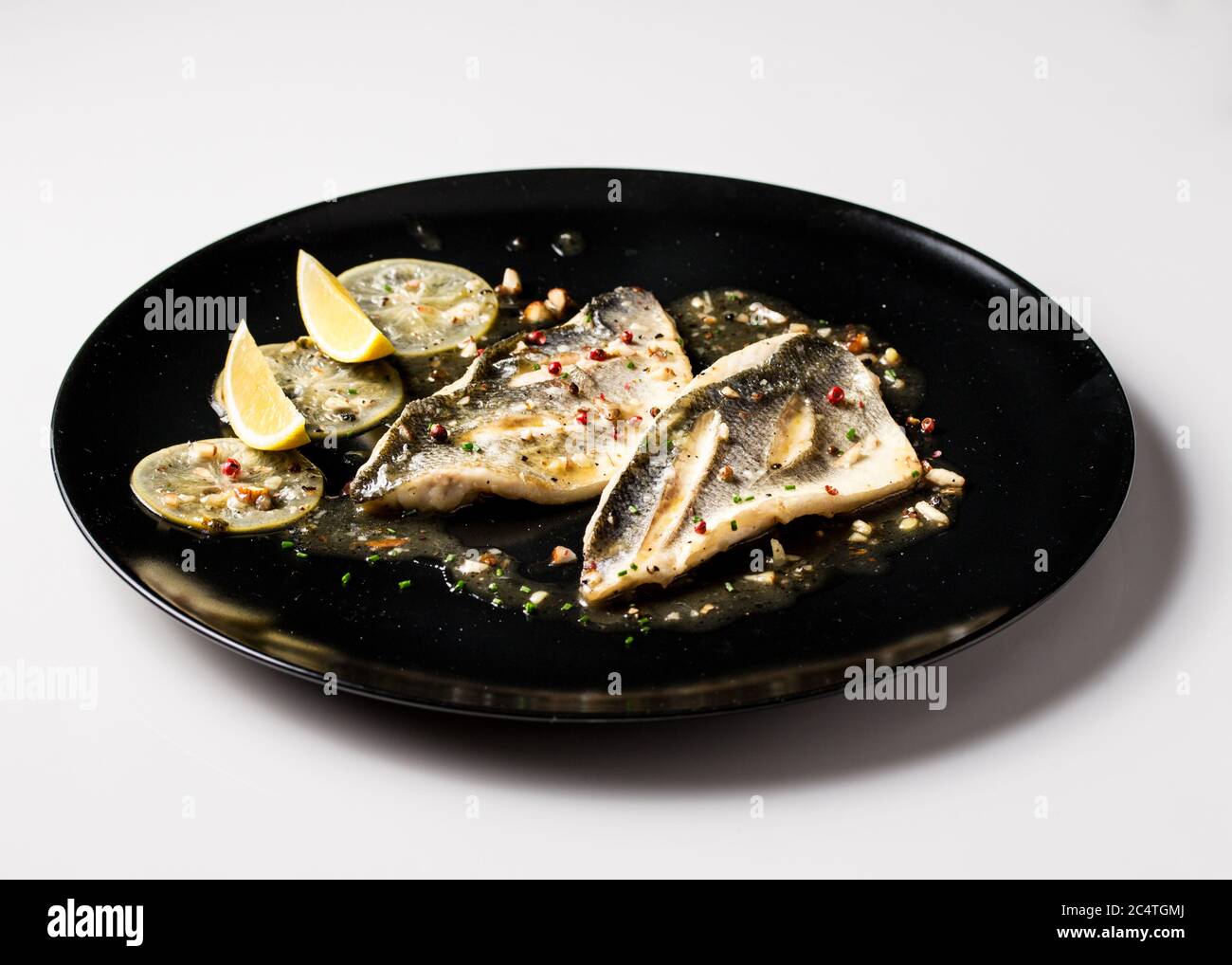 Delicious dish made of cooked fish garnished with salt, pepper, and ...