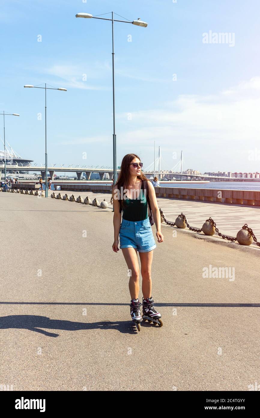 girl roller skating on the promenade rides sidewalk exercise Stock