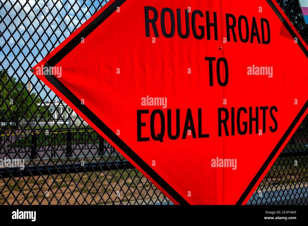 A road construction style sign reads “Rough Road to Equal Rights,” on fence around Lafayette Square / White House, Washington, DC, United States Stock Photo