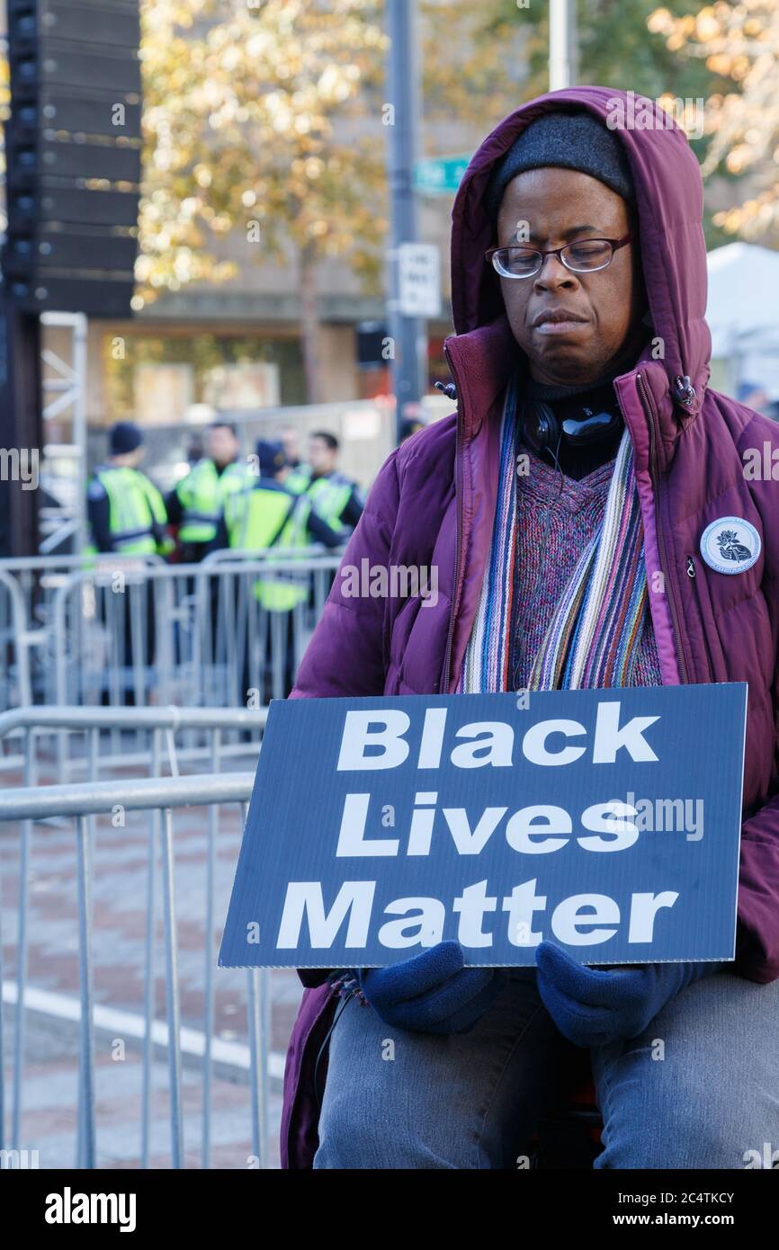 Seattle, USA. 27th, November, 2015. An African American woman in silent protest with her eyes closed and Black Lives Matter sign in her hands. Stock Photo