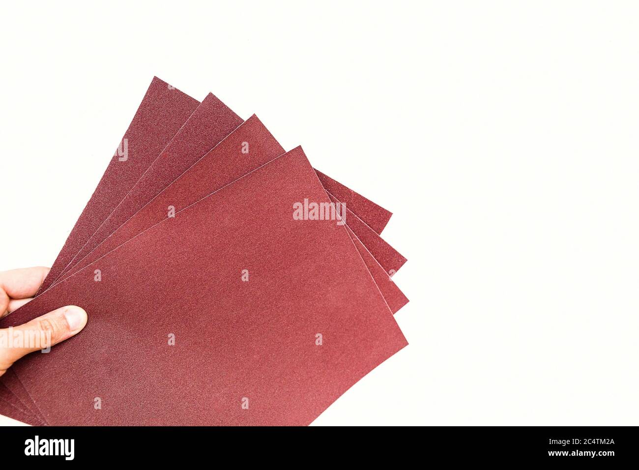 sandpaper in hand isolated on white background Stock Photo Alamy