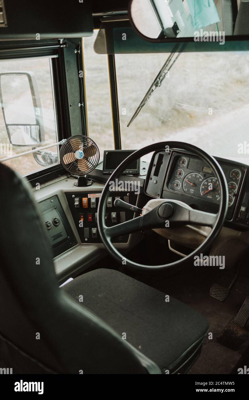 Vertical shot of a bus driver&rsquo;s seat with a small fan on the dashboard