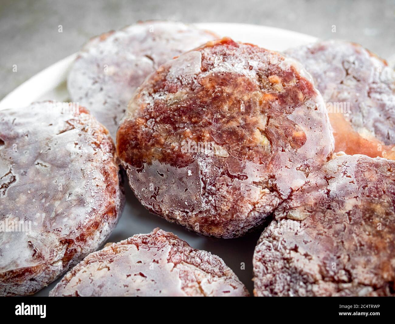 Frozen beef burgers prepare to fry. Closeup homemade juicy minced meat