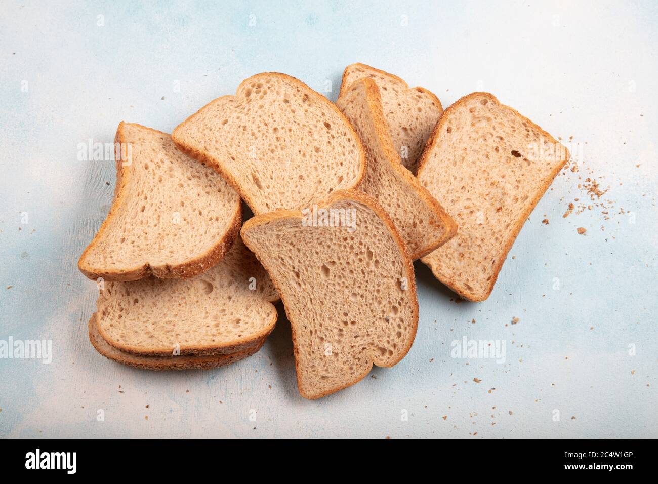 Macrophotography of green mildew on a stale bread. Surface of moldy bread. Spoiled bread with mold. Moldy fungus on rotten bread. Top view. Stock Photo
