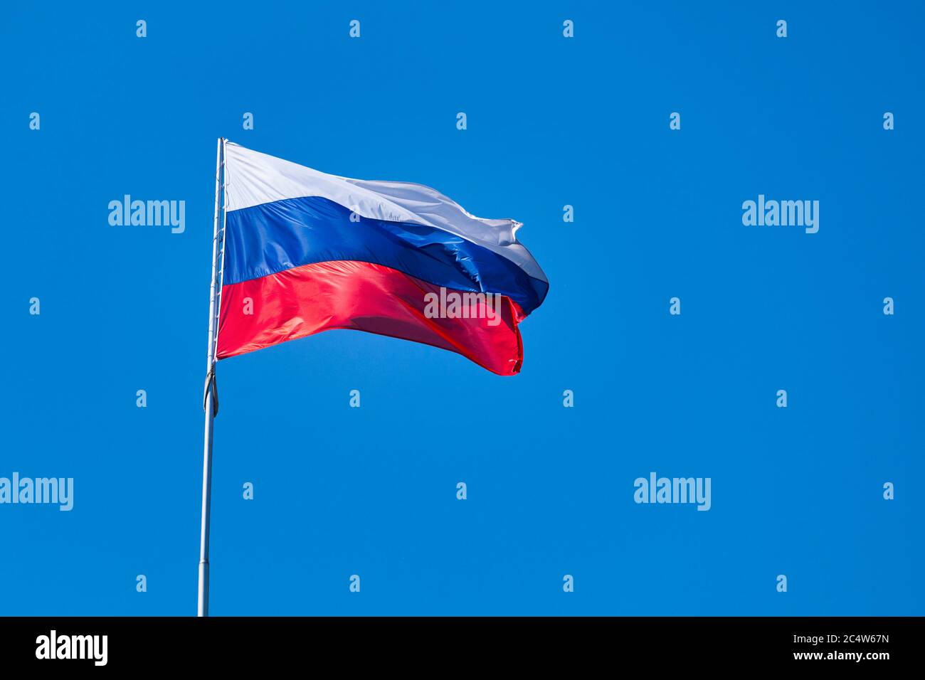 Russian flag waving atop of its pole. Stock Photo