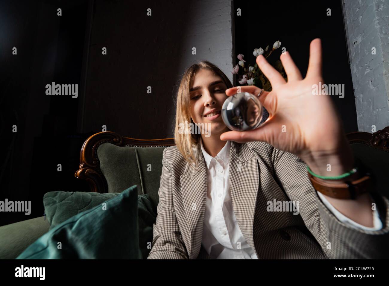 Woman in business suit holding crystal ball Stock Photo - Alamy