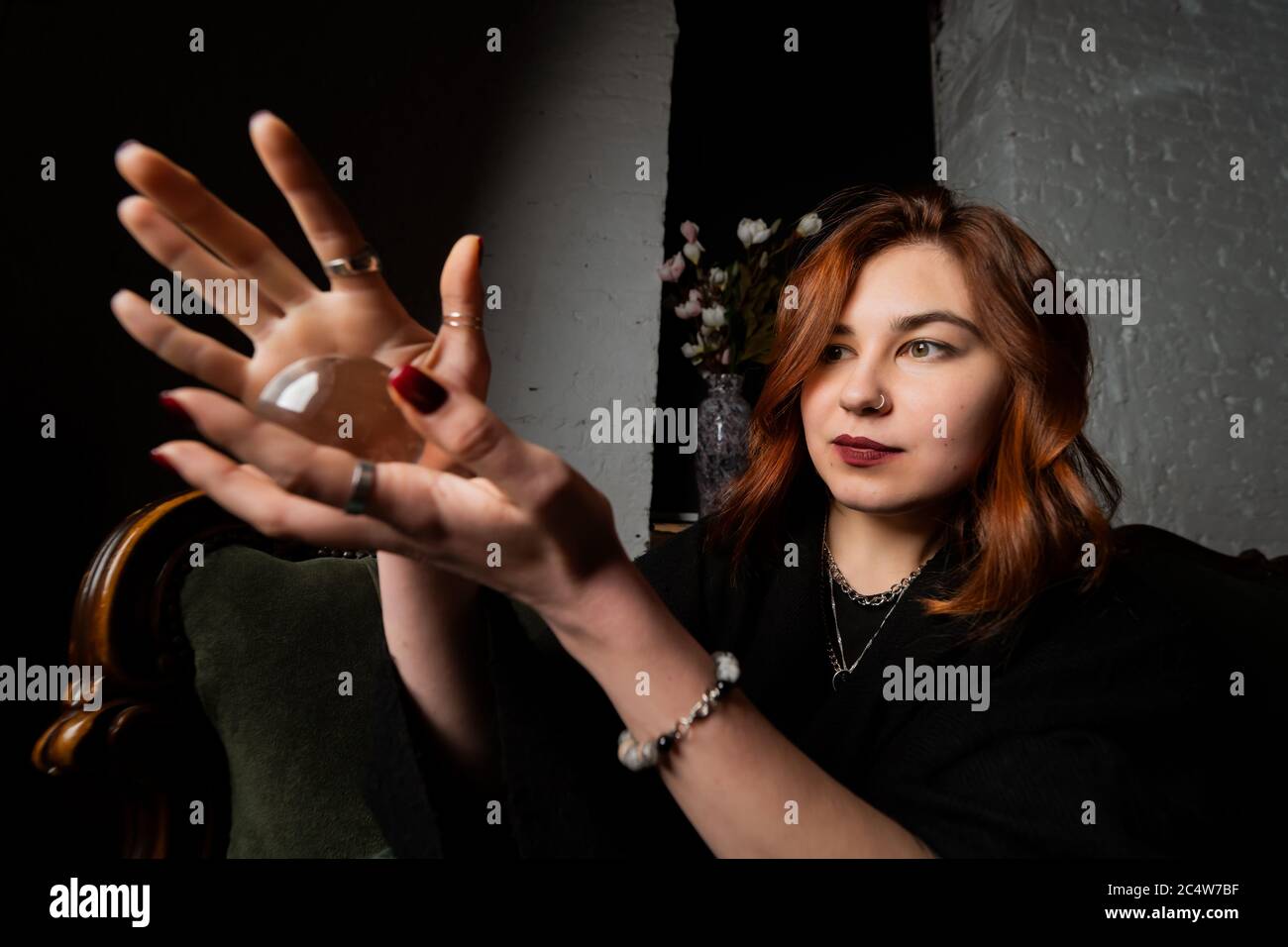 Woman in black suit holding crystal ball Stock Photo - Alamy