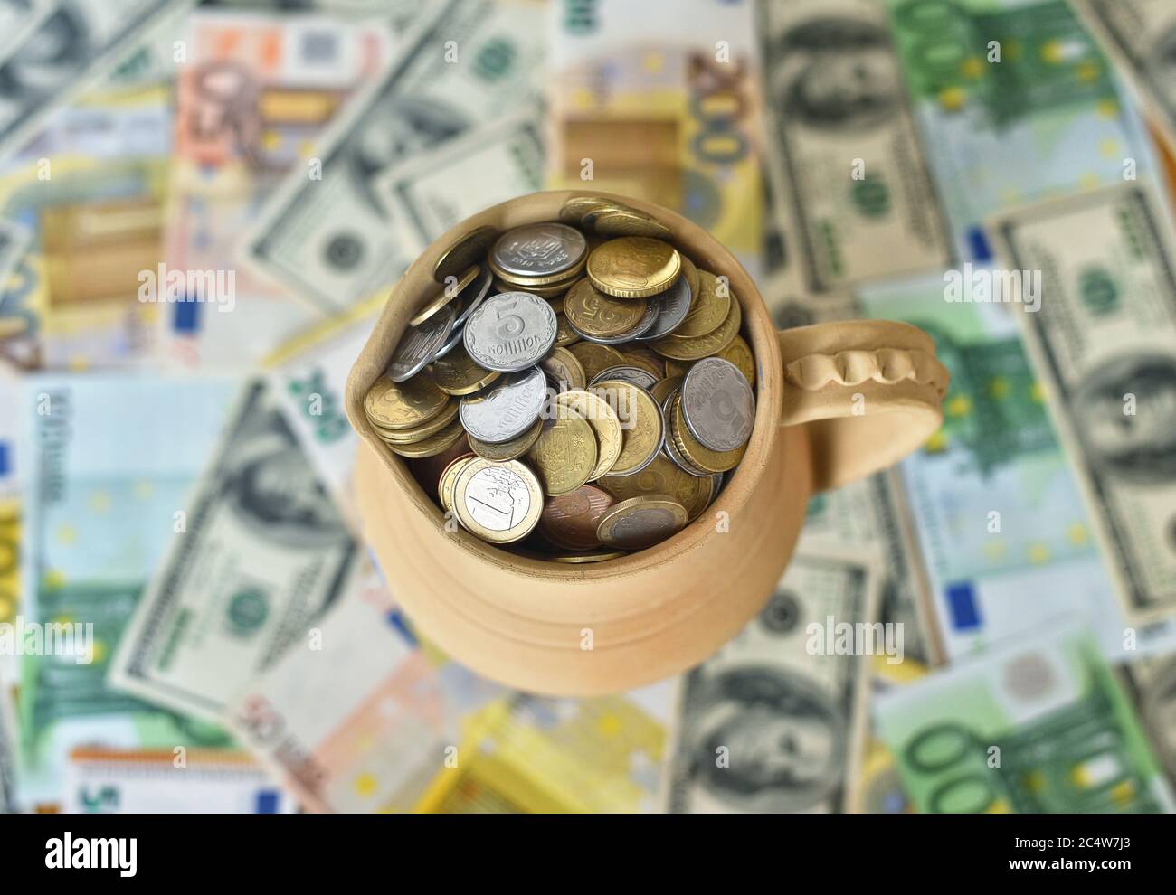 jug with coins on a table with money Stock Photo