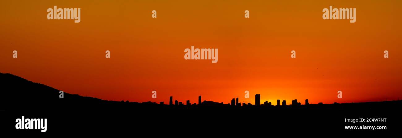 Spectacular Benidorm skyline at sunset with orange sky Stock Photo