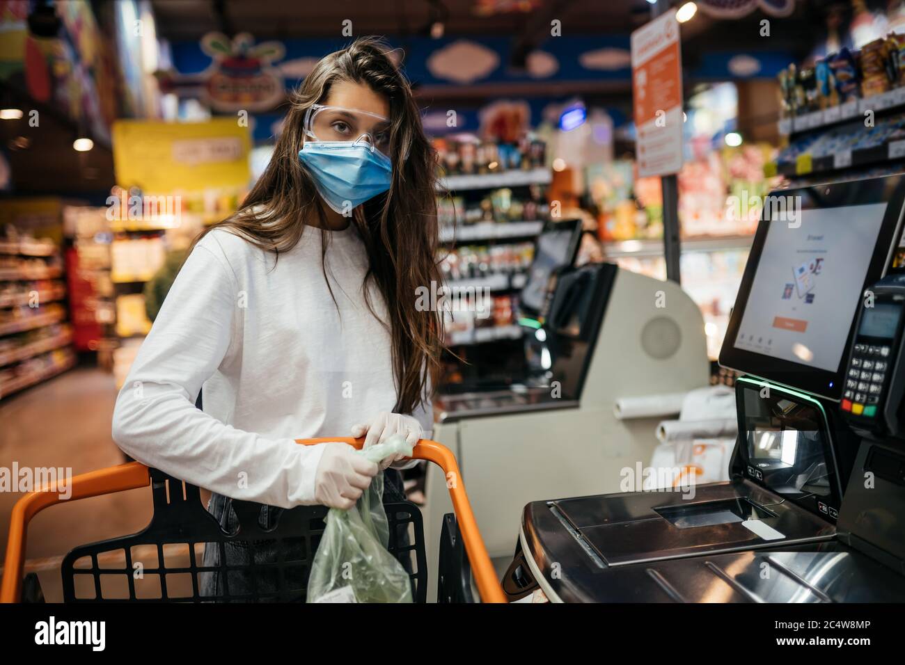 A young woman scans products in a mask and gloves Stock Photo - Alamy