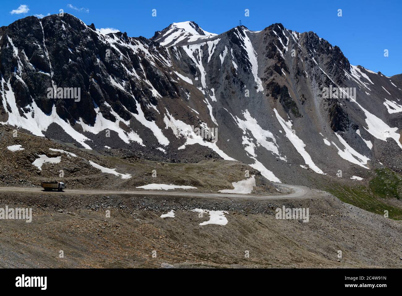 Truck driving on a high road in the Tian Shan mountains of Kyrgyzstan Stock Photo