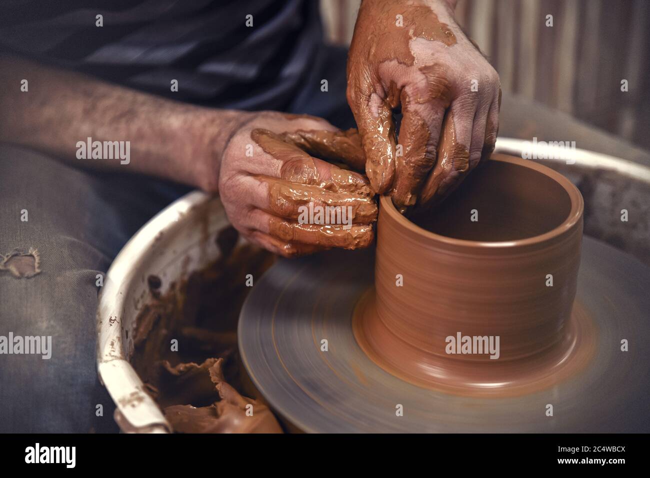 Pottery. The master at the potter's wheel, produces a vessel of clay Stock Photo